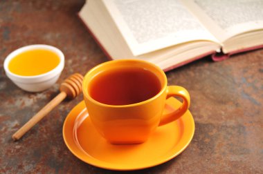 Sonbahar natürmort fincan çay, bal ve kitap masada