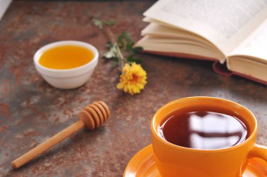 Sonbahar natürmort fincan çay, bal ve kitap masada