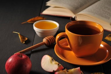 Sonbahar natürmort fincan çay, bal ve kitap masada