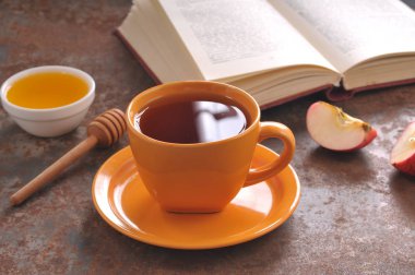 Sonbahar natürmort fincan çay, bal ve kitap masada