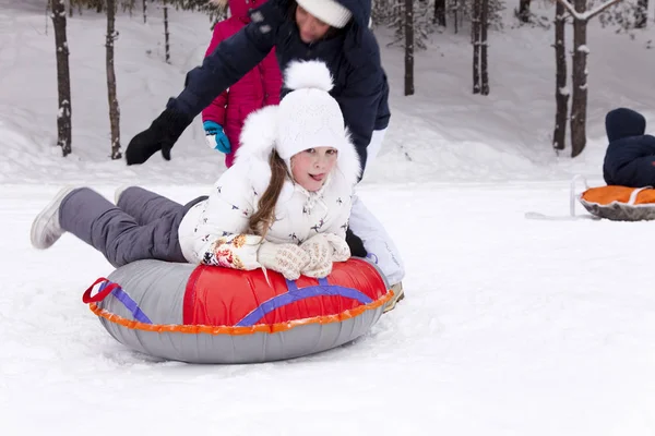 Feliz niña se prepara para deslizarse por una colina nevada . — Foto de Stock