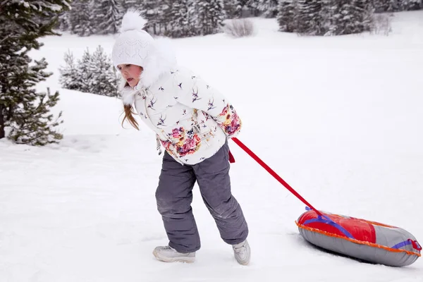 Malá holčička pásku snowtubing. — Stock fotografie