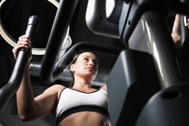 Genç bir kız için spor salonunda giriyor. Kardiyo egzersiz.