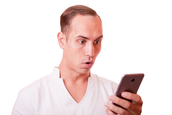 Surprise. portrait of young man texting on a mobile phone on a w — Stock Photo, Image