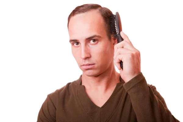 Young man combing the hair of a white background — Stock Photo, Image