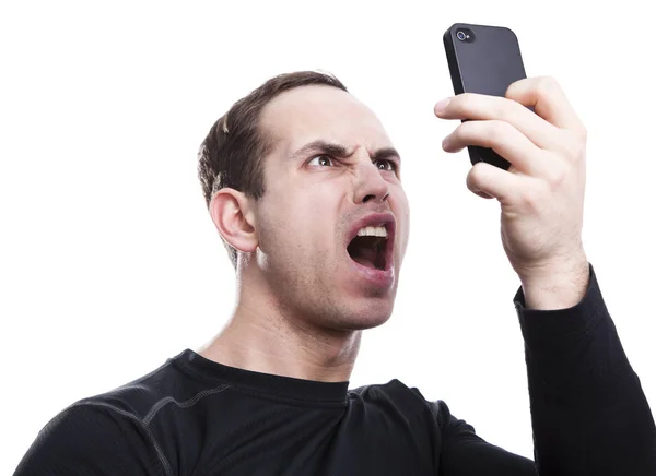 Angry young man talking on smartphone — Stock Photo, Image