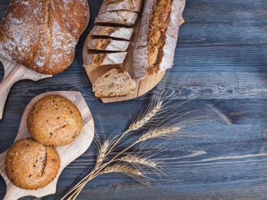 Doğrama tahtaları ve buğday kulakları üzerinde ekmek