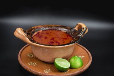 Meksika sığır eti güveci ve limonlar kil bir kasede servis edilir..