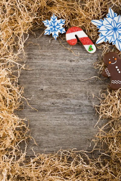 Weihnachtsrahmen aus Tannenzweigen. Dekoration bemalter Lebkuchen. Lebkuchenmann, Weihnachtsstock und Schneemann. unter dem Text platzieren. Kopierraum. — Stockfoto