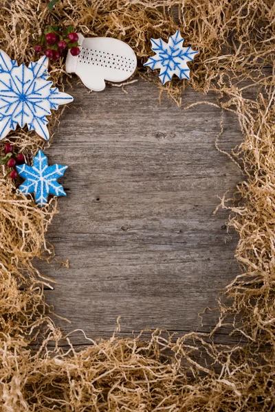 Kerst frame van pijnboomtakken. Decoratie van geschilderde gember peperkoek. Speculaaspop, Kerstmis riet en sneeuwpop. Onder de tekst te plaatsen. Kopiëren van ruimte. — Stockfoto