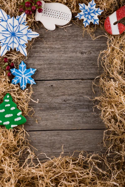 Vánoční rám z borových větví. Dekorace z malovaných zázvorový perník. Perníkový panáček, vánoční cukrové třtiny a sněhulák. Umístěte pod textem. Kopírovat prostor. — Stock fotografie