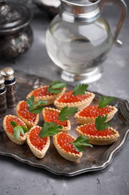 Kırmızı havyar, şenlikli bir tablo. Balık davranır. Vintage çanak çömlek