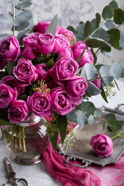 Hermoso ramo. Rosas de Austin en un jarrón vintage. Las tijeras cortan la rosa acostada en la bandeja. Copiar espacio . — Foto de Stock