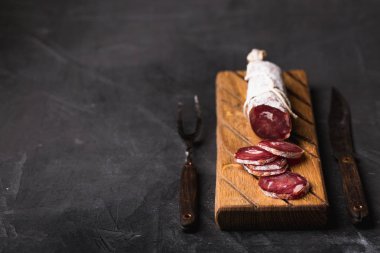 Taze Salam bir vintage yönetim kurulu üzerinde. Vintage çatal çatal ve bıçak bir siyah arka plan kaplı. Kopya alanı.