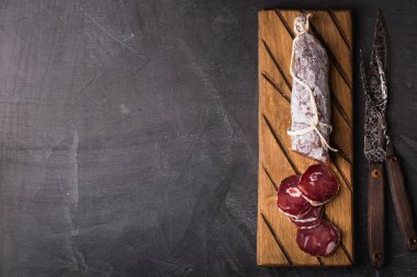 Taze Salam bir vintage yönetim kurulu üzerinde. Vintage çatal çatal ve bıçak bir siyah arka plan kaplı. Kopya alanı.