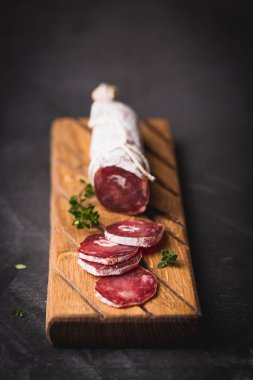 Taze Salam bir vintage yönetim kurulu üzerinde. Vintage çatal çatal ve bıçak bir siyah arka plan kaplı. Kopya alanı.