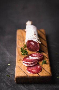 Taze Salam bir vintage yönetim kurulu üzerinde. Vintage çatal çatal ve bıçak bir siyah arka plan kaplı. Kopya alanı.