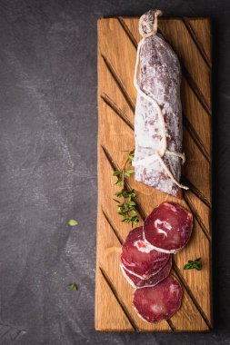 Taze Salam bir vintage yönetim kurulu üzerinde. Vintage çatal çatal ve bıçak bir siyah arka plan kaplı. Kopya alanı.