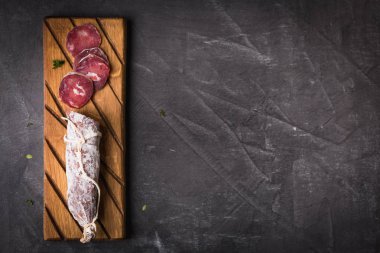 Taze Salam bir vintage yönetim kurulu üzerinde. Vintage çatal çatal ve bıçak bir siyah arka plan kaplı. Kopya alanı.