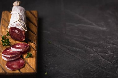 Taze Salam bir vintage yönetim kurulu üzerinde. Vintage çatal çatal ve bıçak bir siyah arka plan kaplı. Kopya alanı.