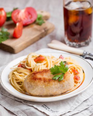 Patty kıyılmış et. Makarna domates ile garnitür. Ev yapımı içki içmek.