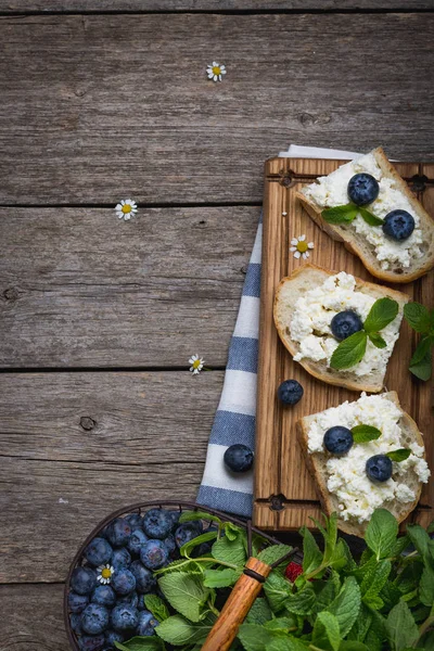 Хлеб с отрубями, ягоды на деревянной доске на деревянном фоне — стоковое фото