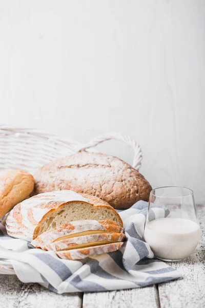 Fresh fragrant bread fresh from the oven. Hearth bread on a wooden table, laid on a cloth linen napkin. — Stock Photo, Image