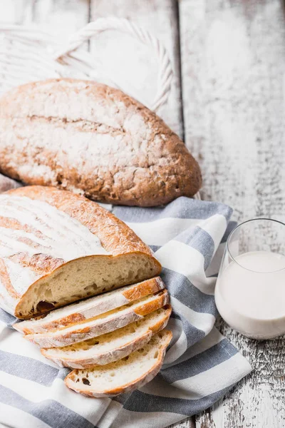 Fresh fragrant bread fresh from the oven. Hearth bread on a wooden table, laid on a cloth linen napkin. — Stock Photo, Image