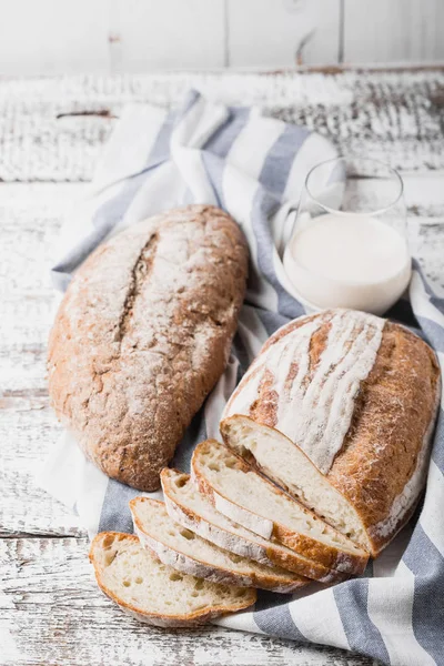 Frisches duftendes Brot frisch aus dem Ofen. Herdbrot auf einem Holztisch, auf eine Leinenserviette gelegt. — Stockfoto