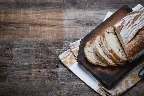 Fresh fragrant bread fresh from the oven. Hearth bread on a wooden table, laid on a cloth linen napkin. — Stock Photo, Image