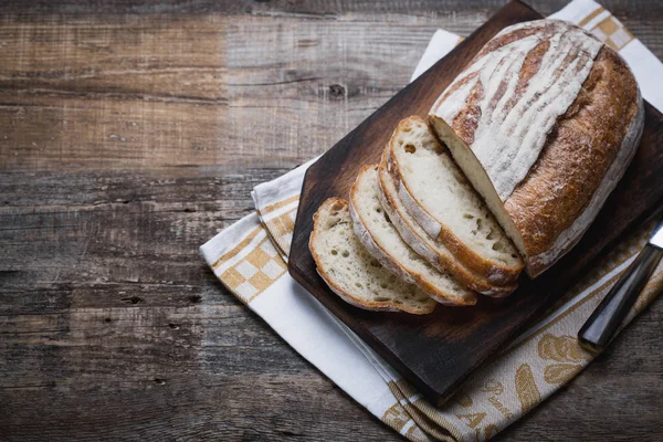 Свежий ароматный хлеб из духовки. Очаровательный хлеб на деревянном столе, положенный на салфетку . — стоковое фото