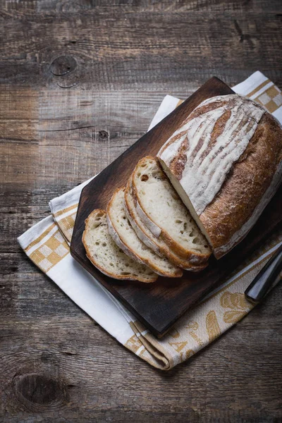 Pan fresco fragante fresco del horno. Entierra el pan en una mesa de madera, puesto en una servilleta de lino de tela . — Foto de Stock