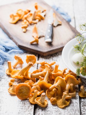 Sonbahar mantar kırmızı, ahşap bir gemide bir bıçakla kesilmiş. Soğan, dereotu masanın üzerinde. Akşam yemeği