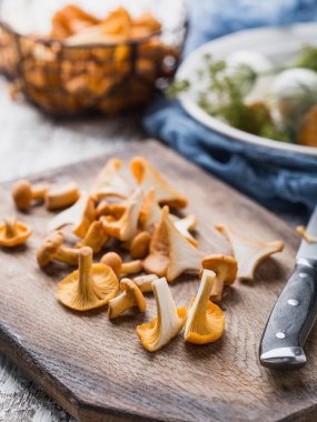 Sonbahar mantar kırmızı, ahşap bir gemide bir bıçakla kesilmiş. Soğan, dereotu masanın üzerinde. Akşam yemeği