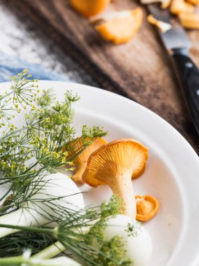 Sonbahar mantar kırmızı, ahşap bir gemide bir bıçakla kesilmiş. Soğan, dereotu masanın üzerinde. Akşam yemeği