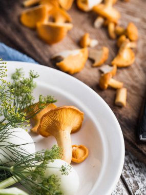 Sonbahar mantar kırmızı, ahşap bir gemide bir bıçakla kesilmiş. Soğan, dereotu masanın üzerinde. Akşam yemeği