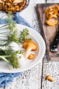 Sonbahar mantar kırmızı, ahşap bir gemide bir bıçakla kesilmiş. Soğan, dereotu masanın üzerinde. Akşam yemeği