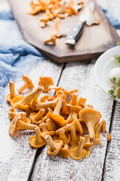 Sonbahar mantar kırmızı, ahşap bir gemide bir bıçakla kesilmiş. Soğan, dereotu masanın üzerinde. Akşam yemeği