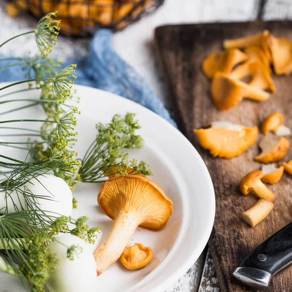 Sonbahar mantar kırmızı, ahşap bir gemide bir bıçakla kesilmiş. Soğan, dereotu masanın üzerinde. Akşam yemeği