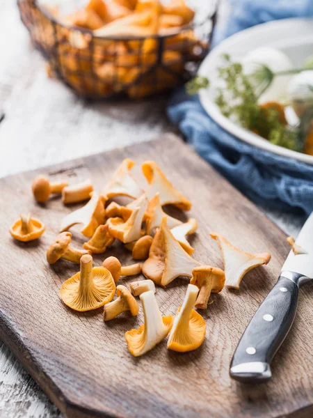 Sonbahar mantar kırmızı, ahşap bir gemide bir bıçakla kesilmiş. Soğan, dereotu masanın üzerinde. Akşam yemeği