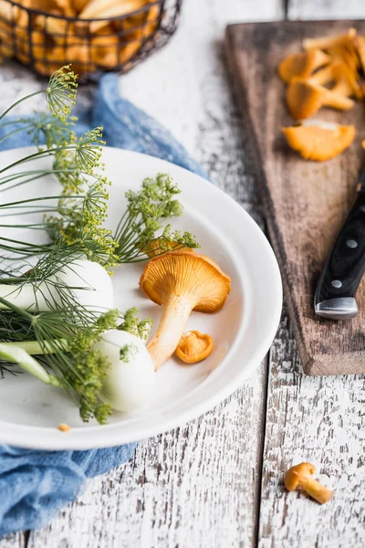 Sonbahar mantar kırmızı, ahşap bir gemide bir bıçakla kesilmiş. Soğan, dereotu masanın üzerinde. Akşam yemeği