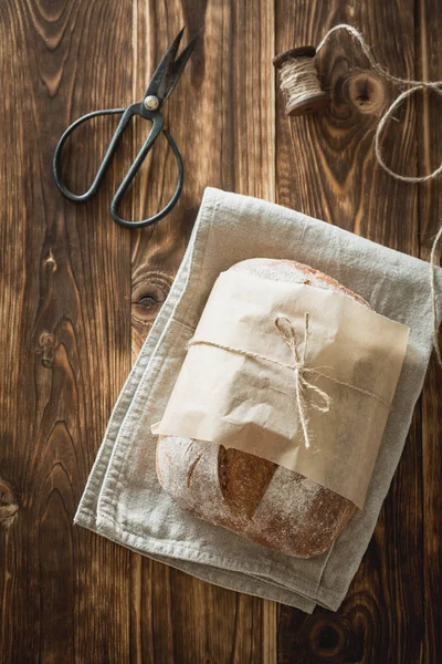 Domácí kváskový chléb, snížit na polovinu na dřevěné desce. Traditi — Stock fotografie