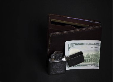 Şık erkek eşyalarının kompozisyonu. Çanta, çakmak, yüz dolarlık banknotlar.