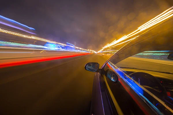 Widok z boku samochodu porusza się w mieście nocy — Zdjęcie stockowe