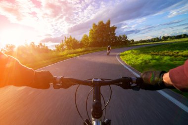 Bir bisiklet ilk kişi perspektif sürme. Güneş doğru Olimpiyat Bisiklet yol.