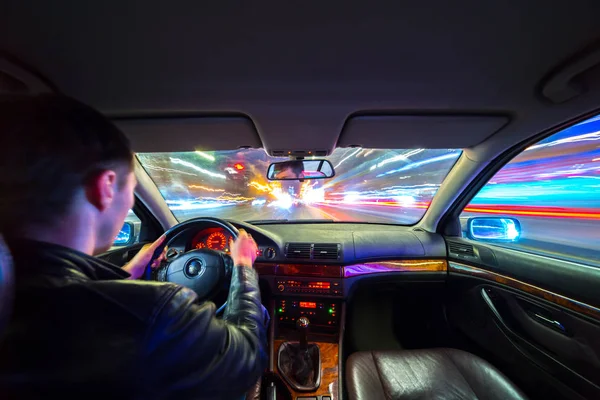 Motorista em carro se move em velocidade rápida à noite . — Fotografia de Stock