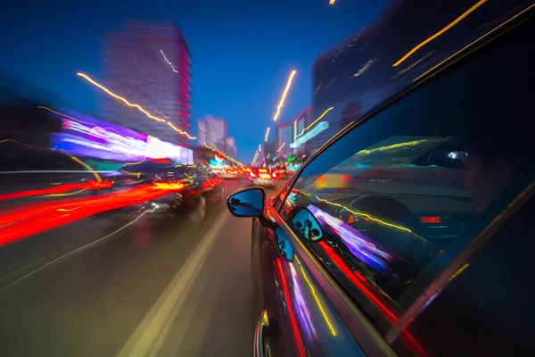 Uitzicht vanaf zijkant van de auto bewegen in een nacht stad — Stockfoto