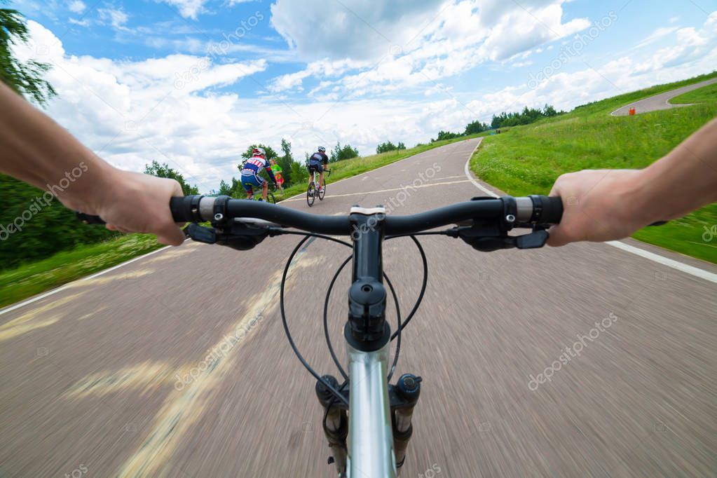 Rider driving bicycle on an asphalt road.