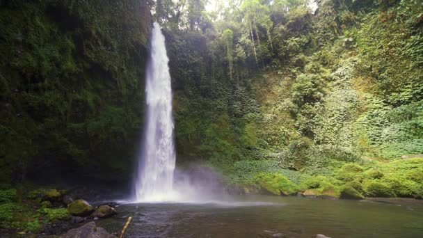 Lanzamiento en cámara lenta frente a una cascada de NungNung en Bali — Vídeos de Stock