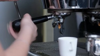 Full process of making coffee on professional coffee machine. Barista preparing double espresso, pouring it in cup.